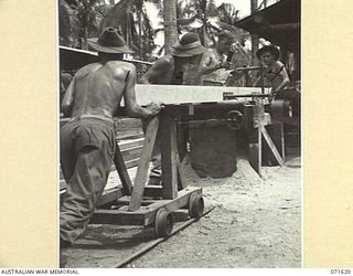 LAE, NEW GUINEA. 1944-03-24. MEMBERS OF THE AUSTRALIAN FORTRESS WORKSHOP IN THE SAWMILL CUTTING OREGON PINE FOR UNIT BUILDING PURPOSES. PICTURED, LEFT TO RIGHT: V185327 CRAFTSMAN (CFN) J. A. ..