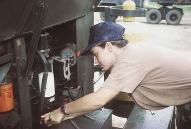 Construction Mechanic Third Class (CM3) Tina Lindner works on one of the many generators which act as auxiliary power sources during typhoons and power outages. These units can be transported to the field where they are used for power sources on job sites