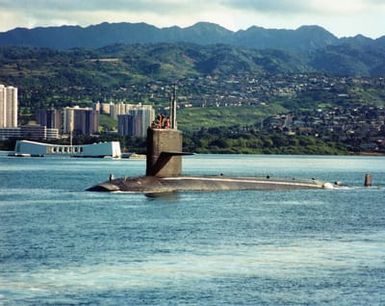 Port bow view of the US Navy (USN) STURGEON CLASS: Attack Submarine, USS HAWKBILL (SSN 666), underway as it exits the harbor at Naval Station Pearl Harbor, Hawaii (HI). The USS Arizona Memorial is visible in the background