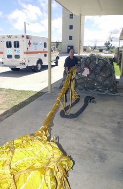 US Air Force (USAF) STAFF Sergeant (SSGT) John Rizzo, from the 7th Expeditionary Maintenance Squadron (EMXS), untangles a landing Drag-chute for a B-52 Stratofortress bomber at Andersen Air Force Base (AFB), Guam