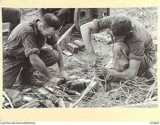 1943-09-28. NEW GUINEA. ADVANCE ON SALAMAUA. FUSING CAPTURED JAPANESE 70 M.M. SHELLS. LATER THE SHELLS WERE FIRED AT THE JAPS FROM A JAPANESE MOUNTAIN GUN CAPTURED DURING THE ADVANCE ON SALAMAUA. ..