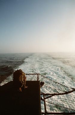 A Marine of the 22nd Marine Expeditionary Unit (22nd MEU) sits at the edge of the flight deck aboard the amphibious assault ship USS SAIPAN (LHA 2) while waiting to board a helicopter during Operation Sharp Edge. Marines of the 22nd MEU are being sent to the U.S. Embassy in Monrovia, Liberia, to augment security and evacuate U.S. and foreign nationals from the fighting between government and rebel forces