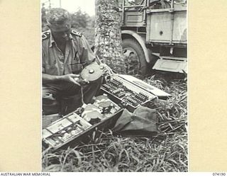 HANSA BAY, NEW GUINEA. 1944-06-21. LIEUTENANT R.G. HAYES, ROYAL AUSTRALIAN NAVY BOMB DISPOSAL UNIT, NEW GUINEA FORCE, DELOUSING JAPANESE LAND MINES SET BY THE RETREATING ENEMY