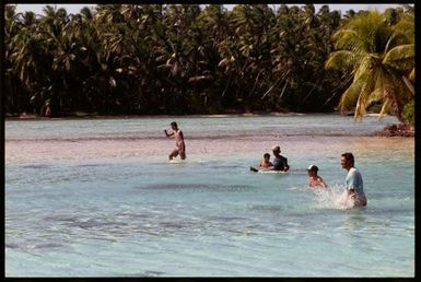 Group of men and boys swimming in lagoon, Cook Islands