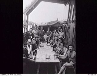 LAE, NEW GUINEA. 1944. THE CREW OF AB422 FRANCES PEAT ON THE DECK OF THE SHIP ENJOYING A CUP OF TEA. THE FRANCES PEAT WAS A FORMER HAWKESBURY RIVER (NSW) VEHICULAR FERRY REFITTED AS AN ARMOURED ..