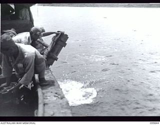 RABAUL, NEW BRITAIN, 1946-02-19. JAPANESE SOLDIERS DUMPING AMMUNITION IN THE SEA NEAR WOTAM ISLAND. DUMPING OPERATIONS OF JAPANESE AMMUNITION AND EXPLOSIVES WERE CARRIED OUT BY JAPANESE UNDER THE ..