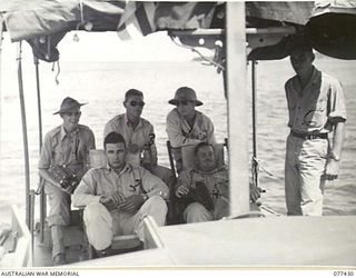 JACQUINOT BAY, NEW BRITAIN. 1944-12-01. SERGEANT BARRETT, PHOTOGRAPHER, AUSTRALIAN MILITARY HISTORY SECTION (1) IN A J TYPE SPEED BOAT WITH OFFICERS OF B COMPANY, 594TH ENGINEER BOAT AND SHORE ..