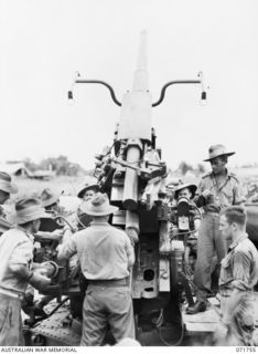 LAE, NEW GUINEA, 1944-03-26. MEMBERS OF C TROOP, 2/6TH HEAVY ANTI-AIRCRAFT REGIMENT (COMPOSITE), OPERATING "MAHFEESGH- TOJO", (FINISH TOJO), NO. 3, 3.7 INCH MOBILE GUN, MKIII DURING AN ALERT. THE ..