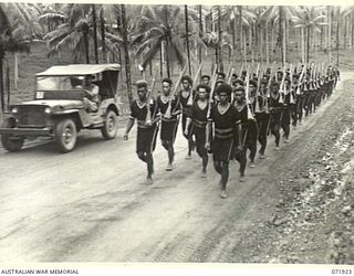 MILNE BAY, PAPUA, NEW GUINEA. 1944-04-01. MEMBERS OF THE ROYAL PAPUAN CONSTABULARY IN THE SAMARAI DISTRICT MARCHING WITH RIFLES AT THE SLOPE DURING A PARADE