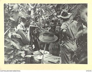 KAMANDRAN, NEW BRITAIN. 1945-02-18. WX5 BRIGADIER R.L. SANDOVER, COMMANDING OFFICER, HOLDING A CONFERENCE WITH OFFICERS OF THE 6TH INFANTRY BRIGADE IN HIS JUNGLE CAMP