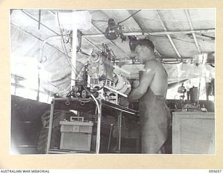 BOUGAINVILLE. 1945-08-30. CORPORAL L.E. HADDEN, 2/4 ARMOURED REGIMENT WORKSHOP, TAKING A READING ON A CALIBRATING PHASING MACHINE, DURING THE TESTING OF TANK EQUIPMENT