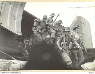 1943-09-25. NEW GUINEA. NADZAB AERODROME. AUSTRALIANS WHO TOOK PART IN THE DRIVE ON LAE LEAVETHEIR TRANSPORT PLANE AT NADZAB AERODROME