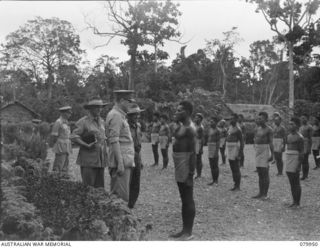 LAE, NEW GUINEA. 1945-03-27. LORD WAKEHURST, KCMG, GOVERNOR OF NEW SOUTH WALES (2), SPEAKS WITH DUMBA, (NO.1 "DOCTA BOY") WHILE INSPECTING THE GUARD OF HONOUR FORMED BY MEDICAL ORDERLIES AT THE ..