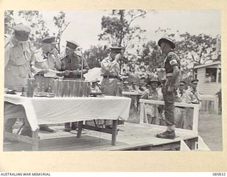 HERBERTON, QLD. 1945-01-19. PRIVATE A C BIGGINS, A COMPANY, 2/8 FIELD AMBULANCE, (5), RECEIVES THE PRIZE WON BY HIS UNIT IN THE STRETCHER BEARERS' CONTEST, FROM LIEUTENANT GENERAL SIR LESLIE J ..