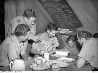 MILNE BAY, PAPUA. 1942-09. IN THE LUNCH TENT ON THE "STRIP" AS THE MILNE BAY AIRFIELD IS CALLED. LEFT TO RIGHT:- SQUADRON LEADER LES JACKSON, COMMANDING OFFICER OF NO. 75 FIGHTER SQUADRON RAAF, ..