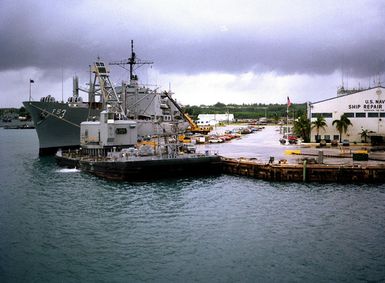 A view of a section of the US Naval Ship Repair Facility with the combat stores ship USS NIAGARA FALLS (AFS 3) moored at left