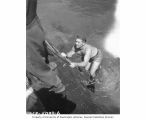 L. B. Marquiss ascending a ladder to the boat after directing divers, Bikini Atoll, 1947