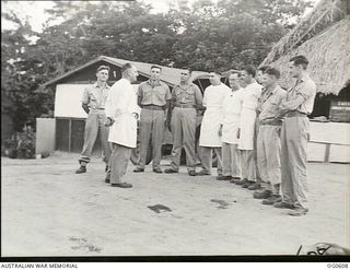 GOODENOUGH ISLAND, PAPUA. 1943-09. NO. 2 MEDICAL RECEIVING CENTRE (DETACHMENT) OUTSIDE THE THATCHED ROOF ORDERLY ROOM. SHOWN: LEADING AIRCRAFTMAN (LAC) R. ALLEN, MAROUBRA, NSW; CORPORAL (CPL) F. ..