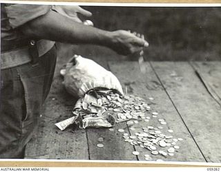 HOPOI, NEW GUINEA, 1943-10-30. JAPANESE INVASION MONEY HANDED IN TO NX155085 CAPTAIN R.G. ORMSBY OF THE AUSTRALIAN AND NEW GUINEA ADMINISTRATIVE UNIT BY THE NATIVES OF THE AREA
