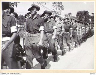 TOROKINA, BOUGAINVILLE. 1945-09-24. MEMBERS OF THE FIELD AMBULANCE, 15 INFANTRY BRIGADE, WEARING THEIR RED CROSS ARMBANDS, PASSING THE SALUTING BASE DURING THE MARCH PAST AT A PARADE HELD AT ..
