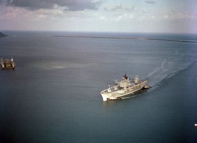 Large harbor tugs maneuver the amphibious command ship USS BLUE RIDGE (LCC 19) into the harbor