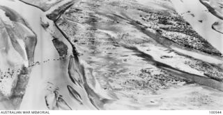 Markham Valley, New Guinea. 1943-09-05. Aerial photograph of Australian troops fording the Markham River, showing the extent of stream. (See also P1566.005)