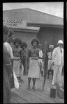 Trobriands man in center holds long yam