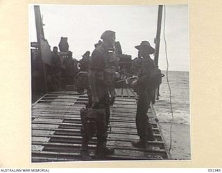 GAZELLE PENINSULA, NEW BRITAIN, 1945-05-15. TROOPS OF A COMPANY, 37/52 INFANTRY BATTALION, EMBARKING FOR WATU PLANTATION AT THE END OF THEIR TREK FROM RILE TO MAVELU, OPEN BAY