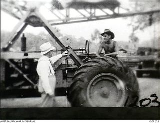 AITAPE, NORTH EAST NEW GUINEA. C. 1944-06. ARTHUR DRAKEFORD, THE MINISTER FOR AIR, TALKING TO THE DRIVER OF A MOBILE CRANE DURING HIS VISIT TO RAAF UNITS IN THE NEW GUINEA AREA