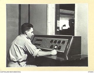 PORT MORESBY, PAPUA, NEW GUINEA, 1944-01-31. THE CONTROL BOOTH AT 9PA, AUSTRALIAN BROADCASTING COMMISSION'S NEW GUINEA REGIONAL STATION, WHICH IS THE FIRST AUSTRALIAN NEW GUINEA BROADCASTING ..