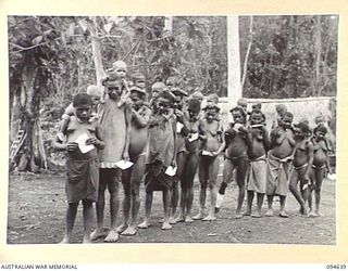 SIPILANGAN, NEW BRITAIN, 1945-07-30. NATIVE WOMEN AND CHILDREN LINING UP FOR MEDICAL ATTENTION AT THE REGIMENTAL AID POST, AUSTRALIAN NEW GUINEA ADMINISTRATIVE UNIT DISTRICT SERVICES TOL REFUGEE ..