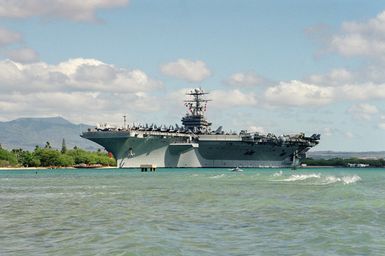 Port bow view of the nuclear-powered aircraft carrier USS ABRAHAM LINCOLN (CVN 72) moving down the channel past Bishops Point as the ship departs Pearl Harbor to take part in Operation RIMPAC 2000. RIMPAC is a multi-national exercise taking part in the waters to the south of Hawaii