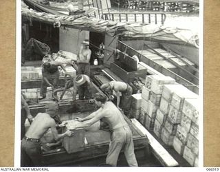 LAE, NEW GUINEA, 1944-06-14/02. TROOPS OF THE 12TH SMALL SHIPS COMPANY, UNLOADING GOODS AND RATIONS AT THE WHARF