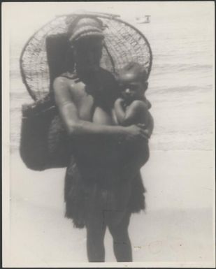 Woman with a woven fishing basket hanging from her forehead down her back  Awar, Sepik River, New Guinea, 1935 / Sarah Chinnery