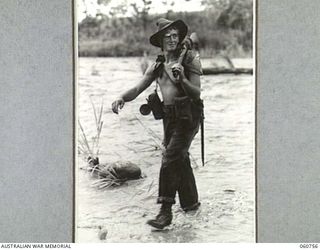 RAMU VALLEY, NEW GUINEA. 1943-11-26. VX50239 LANCE BOMBARDIER W. J. INDIAN OF C TROOP, NO. 8 BATTERY, 2/4TH. AUSTRALIAN FIELD REGIMENT WADING AROSS THE EVAPIA RIVER