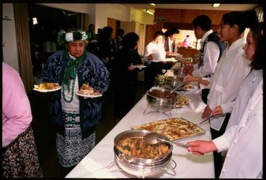 People serving food from a buffet table, Niue