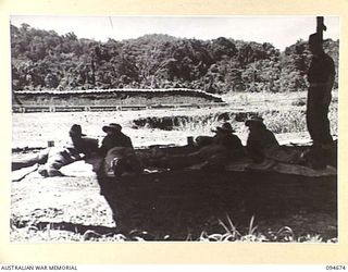 YALU, NEW GUINEA. 1945-08-03. STUDENTS ON THE RIFLE RANGE AT NEW GUINEA TRAINING SCHOOL, RECEIVING INSTRUCTION IN GROUPINGS FROM CAPTAIN J.A. SHIMELD