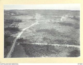 LAE, NEW GUINEA. 1944-03-30. AN AERIAL VIEW OF THE MALAHANG PLANTATION WITH THE BUSU ROAD ON THE LEFT, AND THE MALAHANG ROAD IN THE FOREGROUND