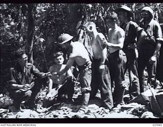 PAPUA, NEW GUINEA. 1942-10. AN AUSTRALIAN COMFORTS FUND ISSUE OF AMENITIES TO THE TROOPS IN THE JUNGLE AT NAURO. MEN OF THE 25TH AUSTRALIAN INFANTRY BRIGADE HEADQUARTERS LINE UP TO RECEIVE THEIR ..