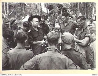 ULUPU, NEW GUINEA, 1945-07-10. BRIG M.J. MOTEN, COMMANDING OFFICER, 17 INFANTRY BRIGADE (1), EXPLAINING FIRST HAND TO THE MEMBERS OF 16 PLATOON, D COMPANY, 2/5 INFANTRY BATTALION, THEIR FUTURE IN ..