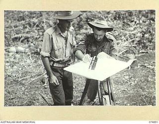 MILILAT, NEW GUINEA. 1944-07-22. NX151008 BOMBARDIER A.R. MCFARLAND (1) AND NX108256 SERGEANT J.B. LILLYMAN (2) OF THE 5TH SURVEY BATTERY, PLANE TABLING THE MILILAT SECTION OF THE ..