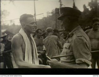 Torokina, Bougainville. 1945-11-04. Major General W. Bridgeford, CB CBE MC, General Officer Commanding 3 Australian Division, presnting a prize to QX30019 Gunner E.J. Reid for winning the fifty ..