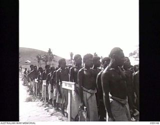 KILA, NEW GUINEA. 1943-10-24. SIDE VIEW OF NATIVES OF THE NATIVE LABOUR CAMP LISTENING TO AN ADDRESS BY PP1 MAJOR GENERAL B. M. MORRIS DSO, GENERAL OFFICER COMMANDING, AUSTRALIAN AND NEW GUINEA ..