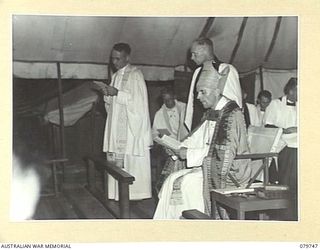 TOROKINA, BOUGAINVILLE, SOLOMON ISLANDS. 1945-03-14. THE DEACON (1), READS FROM THE BIBLE AT A CONFIRMATION SERVICE IN THE TENT CHAPEL OF THE 2/1ST GENERAL HOSPITAL. VX91744 CHAPLAIN P.N.W. STRONG, ..
