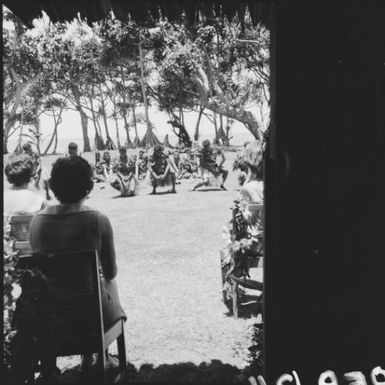 A group of Fijian men performing a dance, dressed in traditional costumes, in front of onlookers, Nasalai, Fiji, 1966 / Michael Terry