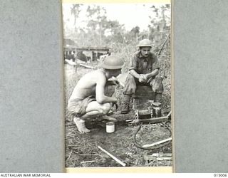 1943-06-15. NEW GUINEA. AUSTRALIANS WATCH JAPANESE PRISONER PREPARING HIS OWN FOOD. THIS PRISONER SAID HE WAS A CHINESE FROM HONGKONG, ALSO THAT HIS PARENTS HAD BEEN KILLED BY THE JAPS, AND HE, ..