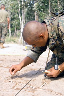 US Marine Corps (USMC) Private First Class (PFC) Florez (left), Eco Company, 2nd Battalion, 3rd Marine Regiment (2/3), Marine Corps Base Hawaii (MCBH), Hawaii (HI), touches up part of a road while building a terrain model at CROCODILE 2003