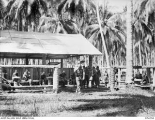 SIAR, NEW GUINEA. 1944-06-20. OFFICERS OF THE 58/59TH INFANTRY BATTALION RELAXING IN THEIR MESS COURTYARD AFTER THEIR MIDDAY MEAL. IDENTIFIED PERSONNEL ARE:- VX106327 LIEUTENANT R.L. MATHEWS (1); ..