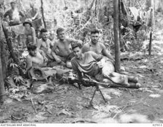 PAPUA, NEW GUINEA. 1942-10. MEN OF THE 2/31ST AUSTRALIAN INFANTRY BATTALION STOP FOR A REST IN THE JUNGLE BETWEEN NAURO AND MENARI, BUT DO NOT LEAVE THEIR .303 BREN MARK 1 LIGHT MACHINE GUN TOO FAR ..