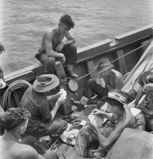 NEW BRITAIN. 1945-05-01. PERSONNEL OF A COMPANY, 37/52 INFANTRY BATTALION, FILL IN TIME WITH A GAME OF CARDS ABOARD THE AK82, A VESSEL ON STRENGTH OF THE 16 WATERCRAFT COMPANY, ROYAL AUSTRALIAN ..